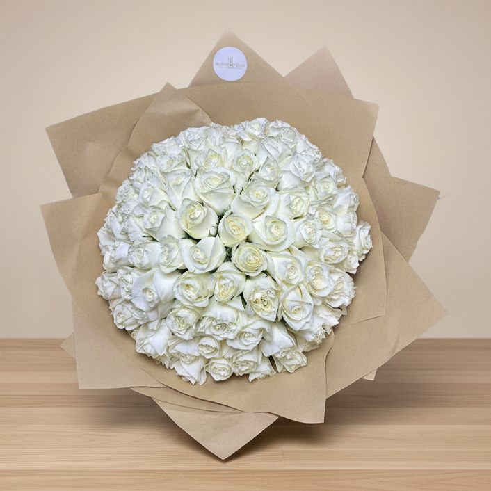 A bouquet of white roses arranged and wrapped in brown paper