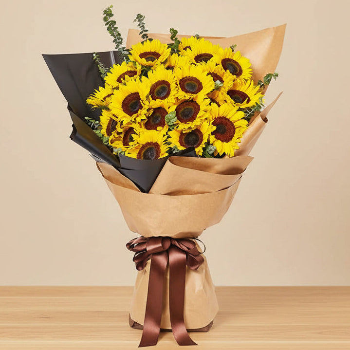 Bouquet of sunflowers wrapped in brown paper with a brown ribbon