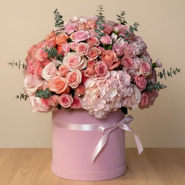 A premium flower box arrangement featuring pink hydrangeas, spray roses, and pink chrysanthemums for delivery in Dubai.