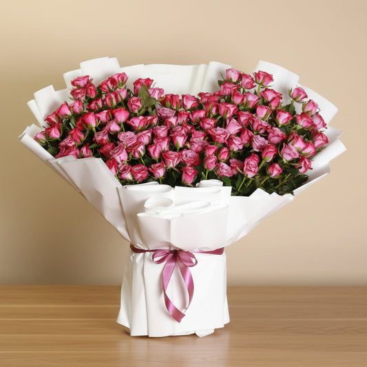 Bouquet of 100 purple roses wrapped in white paper with a purple ribbon
