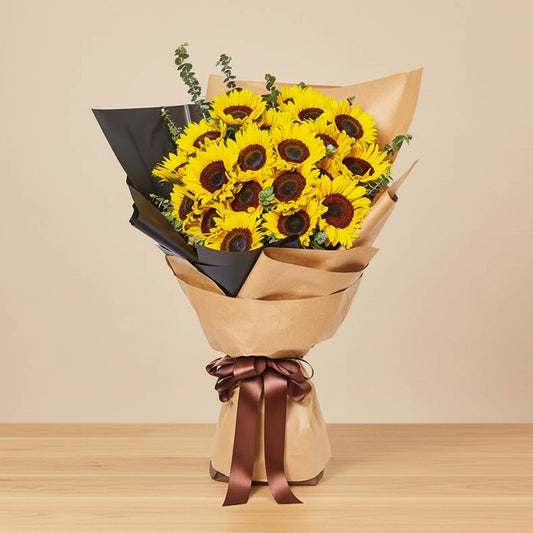 Bouquet of sunflowers wrapped in brown paper with a brown ribbon