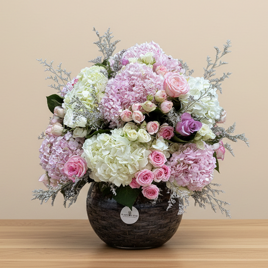 flower arrangement of of pink and white hydrangea and roses in a glass vase