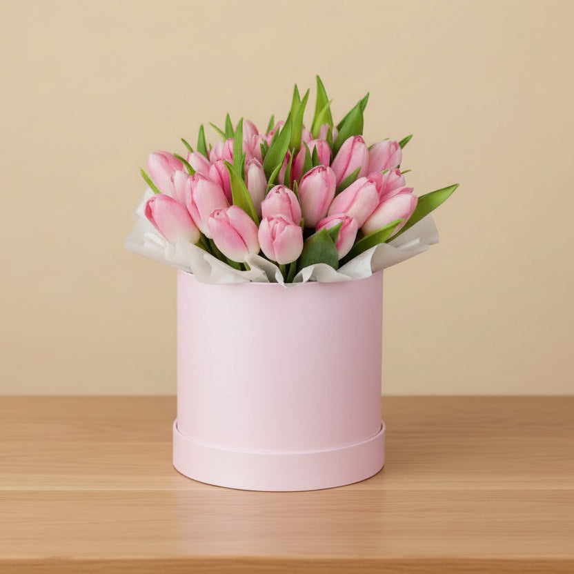 Fresh pink tulip arrangement in a pink round hat box